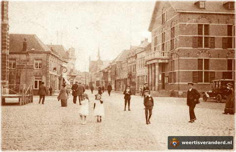 Het stadhuis op de Markt is voorzien van een nieuwe voorgevel met balkom door architect Rouleau. Let eens op de kleding uit die tijd en op het oude T-Fordje.