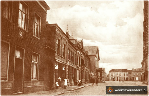 Gezicht vanuit de Langstraat op de Markt. In de gevel links ziet u nog gevelstenen van Herberg “de Swaen” met het jaartal 1779. Op de achtergrond magazijn “Het Anker” nu het café “De Gruyter”.