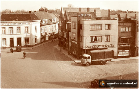 P. de Gruyter & Zn, een grootwinkelbedrijf in levensmiddelen, bouwde in heel Nederland deze fraaie panden. Links ernaast was, en is nog, electro Rechmann gevestigd. Daarnaast had Leijendeckers een schoenenzaak. De poort bij Kneepkens is ver