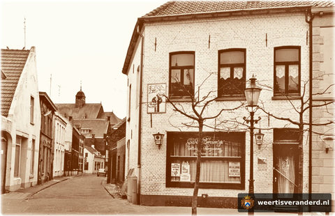 Café “’t Swaentje” van Ton Mathijsen bij de ingang van de Schoolstraat. De drie huizen links op de foto stammen uit de achttiende eeuw. Op de plaats van het grijze pand staat sinds 2006 een stadsvilla. Op de achtergrond het torentje van de