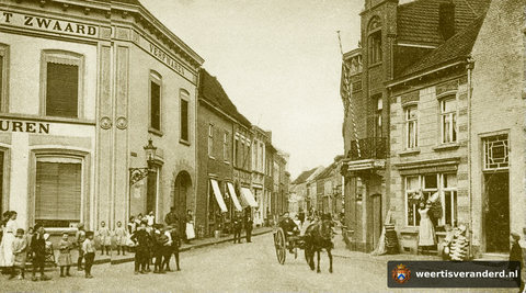 Hier heeft het pand van Koloniale Waren Het Zwaard nog een grote poort aan de zijde van de Hoog straat. Deze verdween bij de verbreding van het pand ernaast, waar later de ijszaak van Väös Janssen gevestigd was. In de winkel rechts met de d