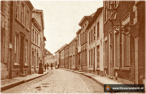 Een foto van de Hoogstraat met zijn statige panden. U kijkt richting Oelemarkt. Rechts bij het rijwiel begint het Prinsenstraatje. Let ook op de prachtige gaslantaarns en bestrating.