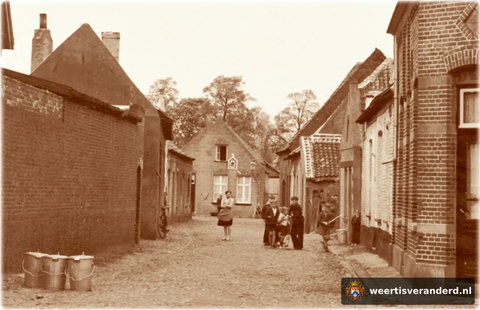We kijken in de richting van de Hogesteenweg. Achteraan rechts in de straat, het hoge huis, het oude logement De Trompet, waarnaar café De Trompet op de Oelemarkt genoemd is.