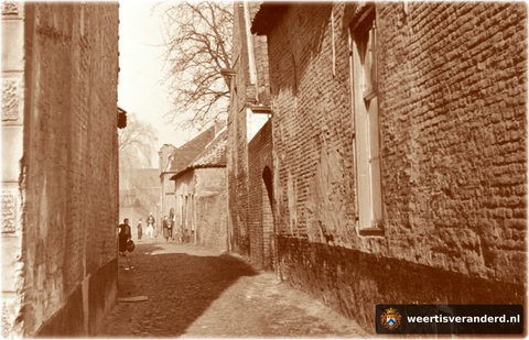 We kijken vanaf de Oelemarkt de Carisstraat in. Rechts de zijgevel van de VIVO winkel van Hein Bongers, later café De Trompet. De huizen erachter zijn alle gesloopt in de jaren vijftig.