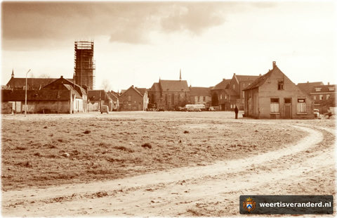 Kaalslag voor een nieuw stadhuis en stadshart. De erg verpauperde wijk werd in de jaren vijftig gesloopt. In 1959 werd begonnen met de heropbouw van de toren. We zien ook nog de oude kapel de bij het Gasthuis (ziekenhuis) hoorde, dat toen i