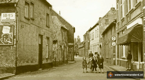 Rechts vooraan bevond zich slagerij Smulders. Daarachter de boerderij van “Noeëts Fien”en dan het woonhuis van de Graef. Helemaal achteraan op de hoek was het kleine kruidenierswinkeltje van Nella en Truus Thijs. Er mocht nog reclame gemaak