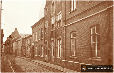 Van rechts naar links ontwaren we het Bisschoppelijk College, het Muntgebouw, dan de graanhandel van Henderiks en vervolgens apotheek Kneepkens met de hertenkop. Daarachter ligt nog het woonhuis van Frans van der Velden waar voorheen boekha