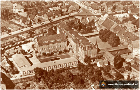 Op deze luchtfoto zien we duidelijk hoe groot het Bisschoppelijk College was. Langs het nieuws HBS gebouw aan de op de voorgrond, kwam later de Nieuwe Markt te liggen. Enkele van de bomen die we hier nog op de cour (speelplaats) van het col