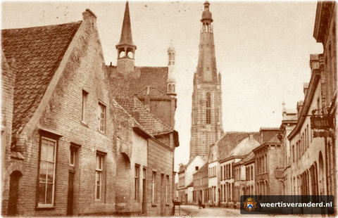 Een heel oude foto van de Langstraat gezien richting markt. Duidelijk te zien dat de Langstraat vele poorttoegangen kende. Rechts het uithangbord van hotel Steegmans.
