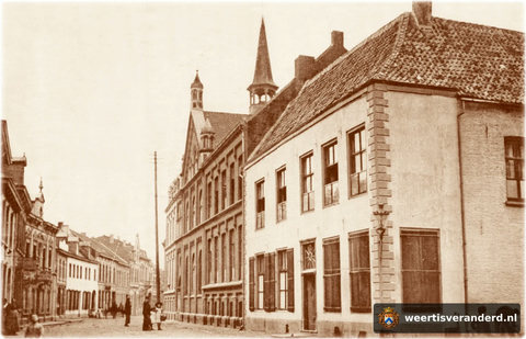 In het hoekhuis op de voorgrond was het klooster van de zusters Ursulinen gevestigd. De overige gebouwen waren scholen, slaapzalen voor de pensionairen en een kapel. Daarvan zien we hier nog het torentje. Let ook op de hoge telegraafmast.
