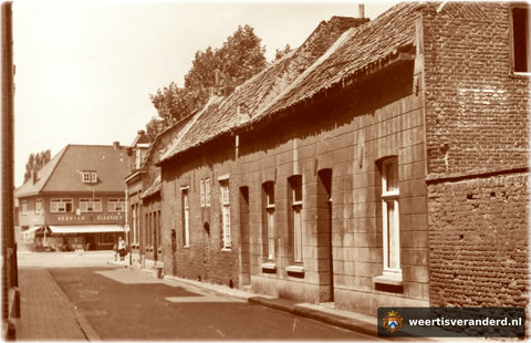 De lage huisjes aan het einde van de straat waren gebouwd als hofje in de zeventiende eeuw door de familie Ververs. In het huis op de hoek woonde vroeger de molenaar van de Binnenmolen, die er vlakbij stond. Op de achtergrond zien we de voo