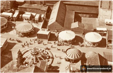 Zelfs in het prille begin van de Nieuwe Markt werd deze al als kermisterrein gebruikt. De gebouwen in het midden zijn nog loodsen van graanhandel Henderiks. Uiterst rechts, met de witte gevel, zien we nog net een stukje van het Muntgebouw a