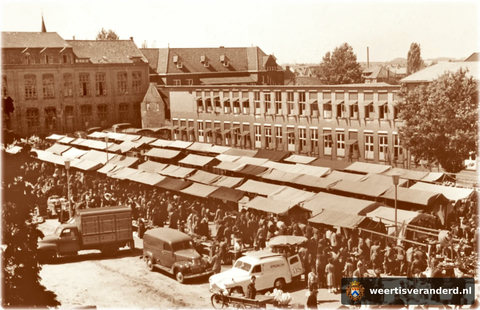 Een drukte van belang op de Nieuwe Markt tijdens de weekmarkt. Op de achtergrond het gebouw van de HBS.