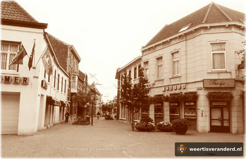 Vanaf de Markt een beeld van een van de best bewaarde straten van Weert. Maar de dame op de fi ets is in overtreding! Aan de linkerkant de fotozaak Sommer van de familie Esser.