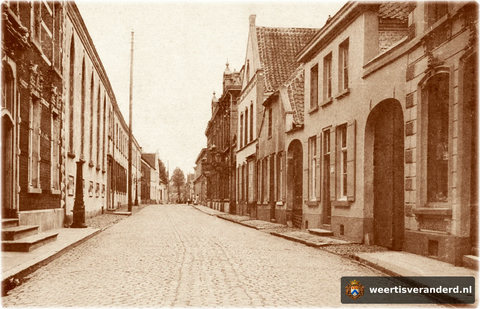 Aan de linkerkant zien we nog een stadspomp staan. De poort aan de rechterkant is van beschuitfabriek Poell en op de plaats waar later Nelleke Nouwen haar winkel had staat nu nog een oude stadsboerderij.