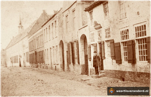 In de Maasstraat bevinden zich nog diverse voetschrapers in de puien van de huizen. Aan de bestrating op deze foto kan men zien dat ze echt nodig waren. Aan weerszijden van de straat loopt een “zieep” als open riool. Let ook op de vele hoge