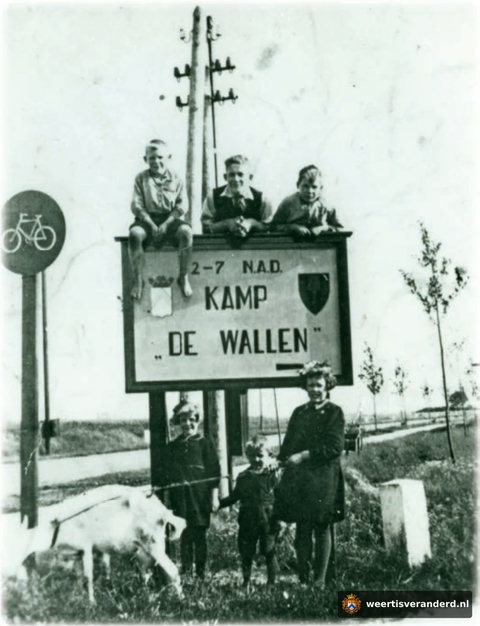 Kinderen bij het bord van kamp De Wallen